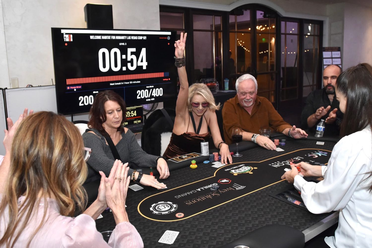 Players at a Habitat for Humanity Las Vegas Charity Series of Poker table, The Poker Timer on the wall