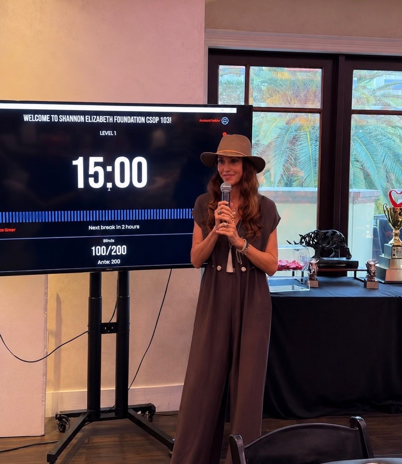 A host welcoming players to a Shannon Elizabeth Foundation Charity Series of Poker event, The Poker Timer on the screen behind