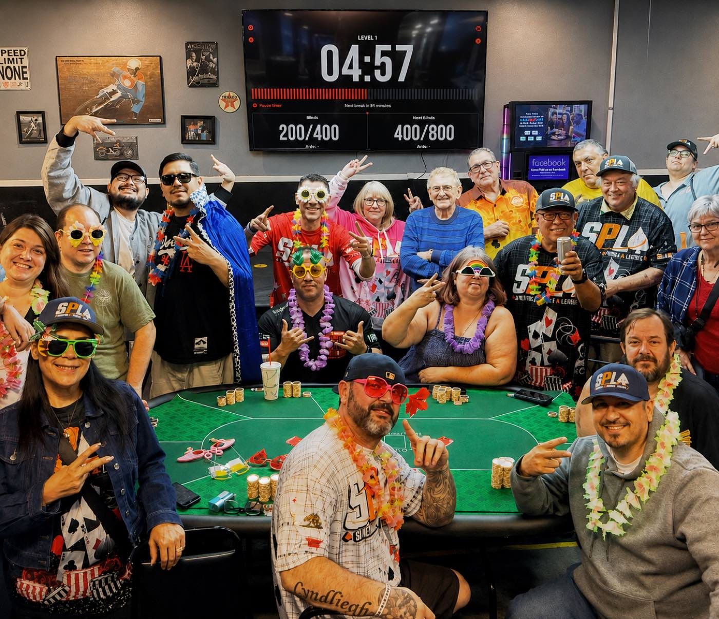 The Sunshine Poker League crew in team gear around the table, The Poker Timer clock on the screen